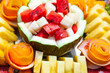 Decorative fruit salad on a fruity background. Sliced watermelon, melon, pineapple and grapefruit.