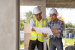 © amnaj - Two young Asian engineer visit the construction site, consult and work on site.