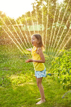 Happy Kid Girl Playing With Garden Sprinkler Run And Jump, Summer