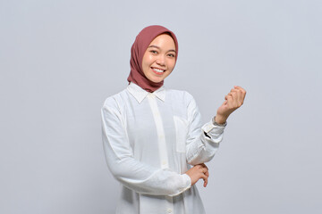 Wall Mural - Smiling young Asian Muslim woman looking at camera feeling confident and happy isolated over white background