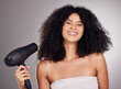 Beauty, portrait and black woman with hair dryer in studio isolated on gray background. Haircare, face and happy female model with machine to dry hairstyle after salon treatment for growth or texture