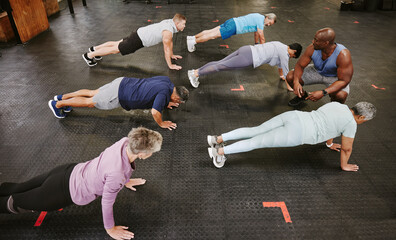 Poster - People, fitness and stretching in class with personal trainer at gym for workout, exercise or training. Diverse group in warm up plank session with coach for healthy exercising or strong core muscles