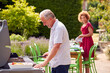 © Monkey Business - Senior Couple Cooking Outdoor Barbeque And Preparing Table For Dinner Party At Home