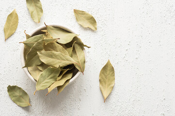 Wall Mural - Dried bay leaves in bowl on rustic background, Spices and herbs concept (Laurus nobilis)