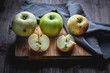 Green and red apples on a wooden board