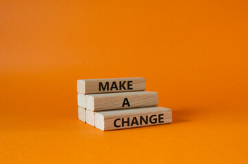 Wall Mural - Make a change symbol. Concept words Make a change on wooden blocks. Beautiful orange background. Business and Make a change concept. Copy space.