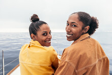 Cheerful Black Women Looking At Camera Against Sea
