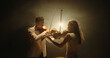 © andreybiling - Duet of two professional violin players having a solo together, performing on stage during concert, spotted by light on black background