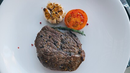 Wall Mural - Grilled sirloin steak with rosemary garlic, tomato on white plate.