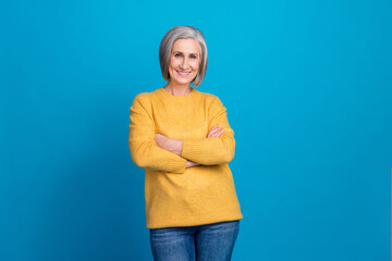 Poster - Photo portrait of senior gorgeous woman crossed hands confident promoter dressed stylish yellow outfit isolated on blue color background