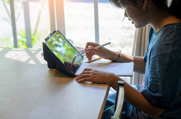 Asian children using tablet and laptop to learning and doing homework at home.Happy Thai Students study online for study to the exam.Education concept.