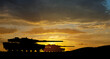 © hamara - Silhouettes of army tanks at sunset sky background. Military machinery.