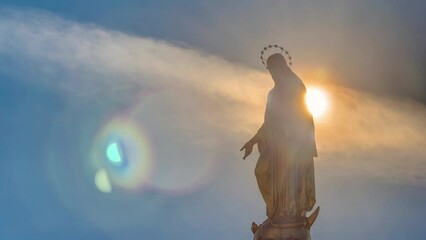 Wall Mural - Holy Mary monument with sun behind it on square in front of the Cathedral timelapse in Zagreb, Croatia. Close up view. Blue sky at sunny day.