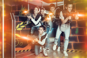 Canvas Print - Glad people posing with laser guns having fun on dark lasertag arena