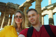 © M-Production - Couple take selfie in front of the remains of the ancient temple.