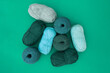 Top view of balls and skeins of yarn in light blue, olive and da