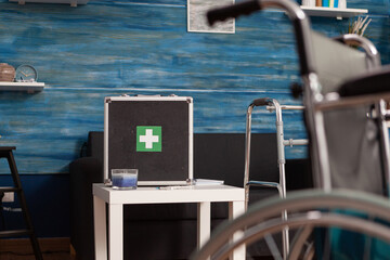 First aid case in the waiting room of a nursing home next to walker as a support for people with disability. Care home for elderly people equipped with all services to assist patients.