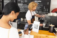 Happy Diverse Male Barista And Woman Scanning Qr Code With Smartphone In Cafe