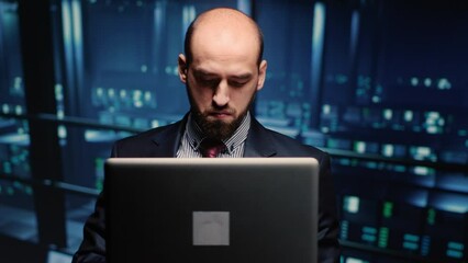 Poster - System administrator checking cluster computer service holding laptop in modern server room. Data center technician analyzing backup digitalization for networking industry. Handheld shot.