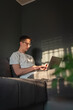 © Dusan - A young guy is laying on his bed while using laptop to study or to do business
