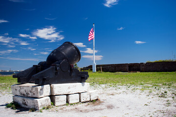 Civil War era cannon at Fort Pickens near Pensacola, Florida. The flag of the United States of America and part of the fort is visible in the background