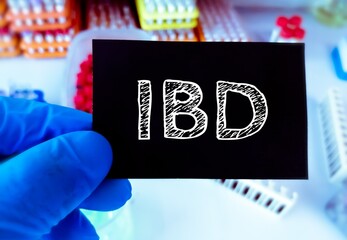 Sticker - IBD or Inflammatory Bowel Disease term on a card in doctor hand. Medical concept.