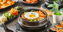 Korean Bibimbap Bowl On Table Top With Many Different Dishes