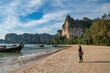 © Noppasinw - Tropical islands view with woman tourist looking at ocean blue sea water and white sand beach at Railay Beach, Krabi Thailand nature landscape