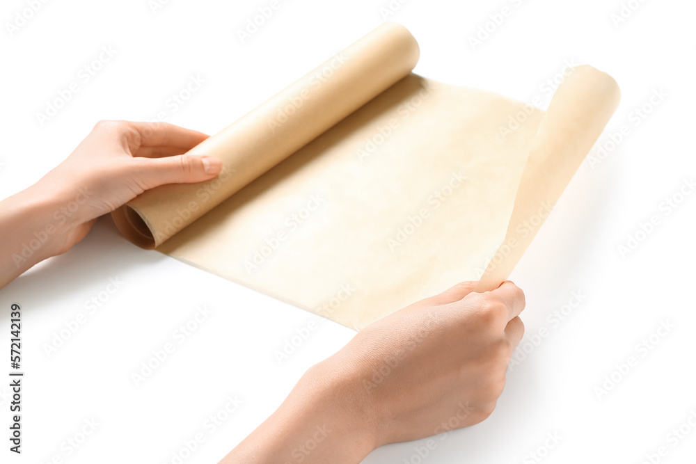 Female hands with roll of baking paper on white background, closeup