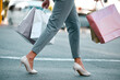 © Phindulo T/peopleimages.com - Shopping bags, woman customer and heels of a girl on a city street in New York with sale bag. Mall, retail fashion shop and store discount with a female walking outdoor after a luxury boutique visit
