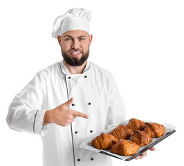 Canvas Print - Male baker pointing at tray of tasty croissants on white background