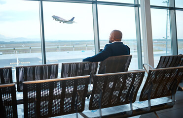 Wall Mural - Airport waiting, black man back and phone for work travel, plane and air flight. Businessman, mobile connection and person sitting with cellphone looking at traveler app info for airplane traveling