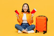 Young woman in summer casual clothes hold mobile cell phone passport ticket isolated on plain yellow background. Tourist travel abroad in free spare time rest getaway Air flight trip journey concept