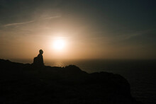 Man Standing Backlit In A Beautiful Sunset Landscape