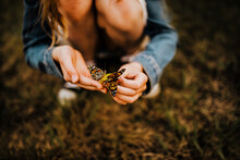 9 YEAR OLD GIRL HOLDING TWO BUTTERFLIES