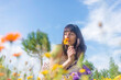 © Cavan Images - Beautiful young girl in dress smelling flowers in the meadow