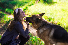 Girl Kissing With Her Dog In Nature