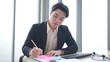 © M Stocker - Asian businessman wearing suit working on desk at office