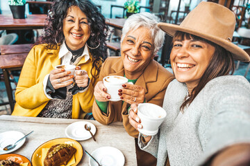 three senior women enjoying breakfast drinking coffee at bar cafeteria - life style concept with mat