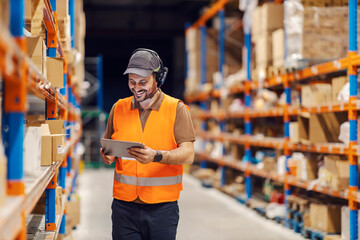 A post office worker is using tablet and headset for tracking shipment while smiling at the tablet.