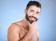 Idea, beauty and natural with a man model in studio on a blue background for skincare, wellness or grooming. Face, beard and skin with a handsome young male thinking about cosmetics or treatment