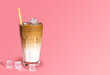 Summer drink background, copy space. Glass of sweet creamy iced coffee , espresso coffee with milk with straw isolated on pink background.	