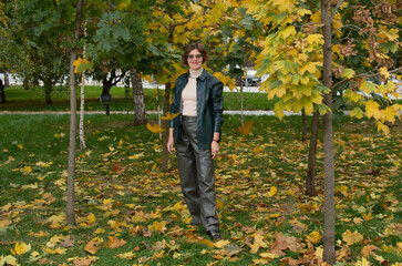 Wall Mural - A woman in leather clothes stands against the backdrop of an autumn maple square