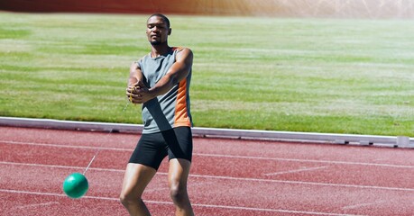 Wall Mural - African american male athlete hammer throwing against sports field in background