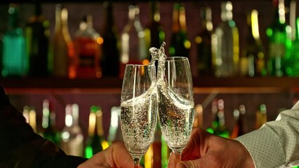 Poster - Super slow motion of cheering champagne drinks in bar. Filmed on high speed cinema camera, 1000 fps. Bar with bottles on background.