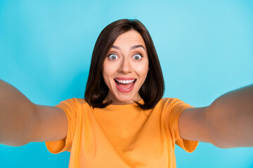 Wall Mural - Portrait of astonished positive girl open mouth unbelievable take selfie isolated on blue color background