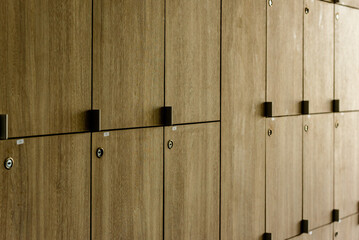 Wooden lockers with key in locker room at school sport club office.