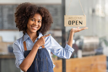 Successful African Woman In Apron Standing Coffee Shop Door. Happy Small Business Owner Holding Tablet And Working. Smiling Portrait Of SME Entrepreneur Seller Business Standing With Copy Space.