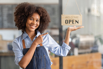 Wall Mural - Successful african woman in apron standing coffee shop door. Happy small business owner holding tablet and working. Smiling portrait of SME entrepreneur seller business standing with copy space.