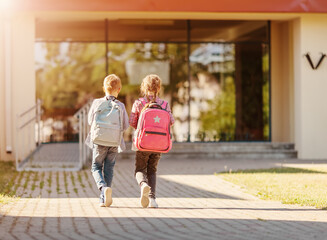 Wall Mural - Girl and boy walking school together to study at it.